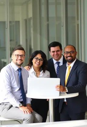 Professional team collaborating with a laptop in a modern corporate office environment